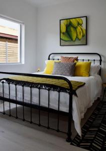 克莱因蒙德Seafront house with a view的一张带黄色枕头的床和墙上的绘画
