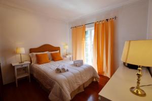 塞图巴尔Azeitao Idílica Moradia T4 no Descanso do Campo的一间卧室配有带橙色枕头的床和窗户。