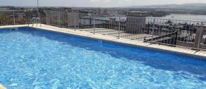 里瓦德奥Apartamento Terraza vistas a la Ria y Parking的大楼内的一个蓝色海水大型游泳池