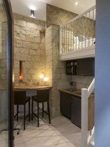 马尔赛Le Lodge de Richard, studio indépendant的厨房配有桌椅和石墙