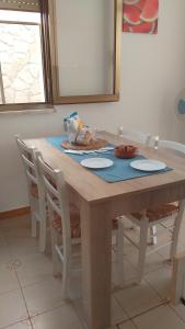 托雷圣乔万尼乌Verdemare的一张带白色椅子的木桌和一张蓝色的桌布