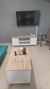 AntimácheiaMama Marina apartement near to the airport的客厅配有咖啡桌和平面电视。