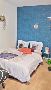 布洛涅-比扬古Cosy Appart Hotel Boulogne -Paris的一间卧室设有一张蓝色墙壁的大床