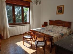 维韦罗内Appartamento doppi bagni sei posti letto的一间卧室配有一张带两把椅子和一张桌子的床。
