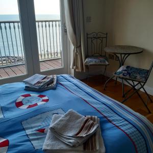 文特诺Kaia Penthouse, waking up to the sound and smell of the ocean的一间卧室配有蓝色的床和毛巾