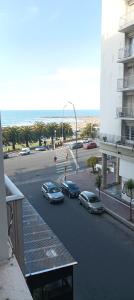 马德普拉塔Departamento vista al mar Playa Las Toscas的一条有汽车停在大楼旁停车场的街道