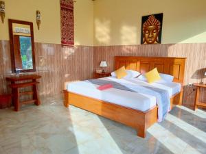 TirtaganggaAlamku Bungalow的一间卧室配有一张大床和床头板