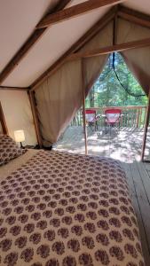 DwightDwight Riverside Inn的帐篷,甲板上配有一张床和两把椅子