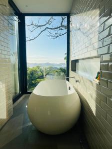 里约热内卢Pousada Rio144的带窗户的浴室内的白色大浴缸