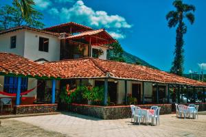 AmagáHotel Hacienda la Bonita的一间设有白色椅子的餐厅以及一座建筑