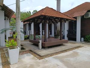 龙运Old Klang Road Homestay Dungun的房屋庭院中的凉亭