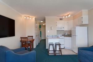 加尔维斯敦Casa Del Mar Beachfront Suites的一间设有厨房和客厅的客房