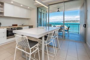 耐莉湾One Bright Point - Stunning Water Views的一个带桌椅的厨房和一个阳台