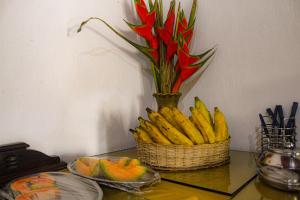 瓜拉米兰加Casarão dos Uchoa的桌上一篮香蕉,一朵花