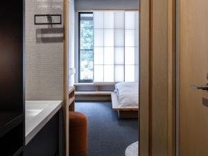 别府別府ホテル塒 Beppu Hotel Negura的一间设有窗户的房间和一张位于房间的床