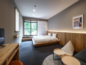 别府別府ホテル塒 Beppu Hotel Negura的一间卧室配有一张床,并在一间客房内配有电视。