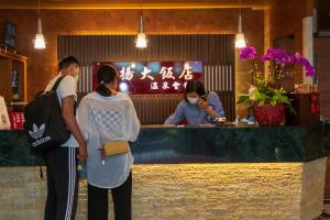 仁爱乡正扬温泉渡假饭店 的两名妇女站在餐厅酒吧