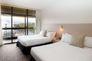 阿德莱德The Terrace Hotel Adelaide的酒店客房设有两张床和一个阳台。