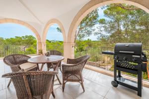卡拉桑塔尼Villa Rosa的一个带桌椅和烧烤架的庭院