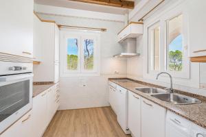 卡拉桑塔尼Villa Rosa的厨房配有白色橱柜和水槽