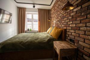 奥尔什丁Apartament Hansa Klossa的卧室设有砖墙、一张床和一张桌子