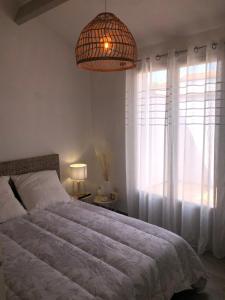 莱马特Maison au cœur de la La Palmyre的一间卧室设有一张床和一个大窗户