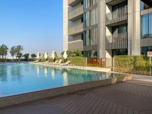 迪拜Modern Urban 3 bedroom apartment Dubai Creek Harbour的大楼前的游泳池