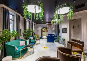 巴库Ivy Garden Hotel Baku的大堂设有绿色椅子和盆栽植物
