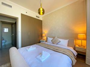 迪拜Modern Urban 3 bedroom apartment Dubai Creek Harbour的一间卧室配有一张大床和两条毛巾
