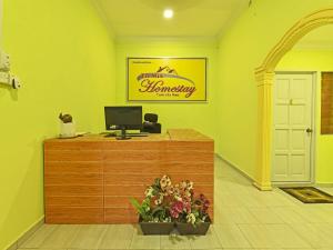 Kampung RajaOYO 90551 Zn Mix Homestay & Roomstay的配有书桌、电脑和鲜花的客房