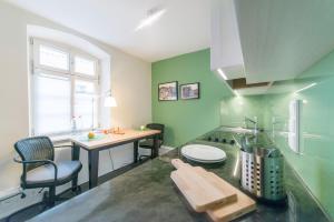 布雷滕Gästehaus am Marktbrunnen的厨房设有绿色的墙壁和桌椅