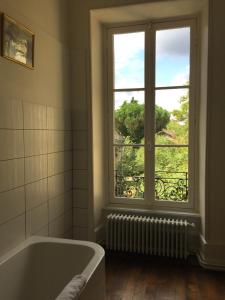 圣莱奥纳尔德诺布拉利斯花园酒店的带浴缸的浴室和窗户。
