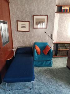 米兰MILAN SOUTH GATE APARTMENT的客厅配有蓝色长沙发及橙色枕头