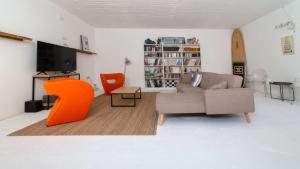 SimotátaKEFI SPITIA的带沙发和橙色椅子的客厅