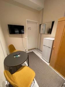 伊瓦洛Kuukkeli Ivalo Airport Inn的客房配有桌椅和冰箱。