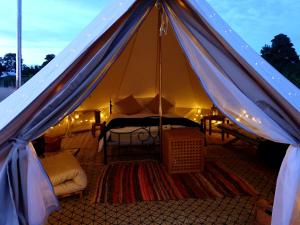 滨海索尔特本Luxury 5m bell tent with log burner near Whitby的帐篷配有一张床和一张桌子