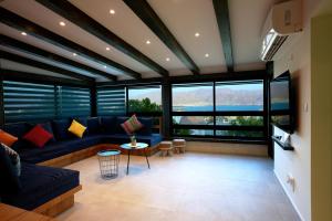 埃拉特RAKEFET - Traveler's House - EILAT的客厅设有蓝色的沙发和大窗户