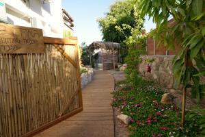 埃拉特RAKEFET - Traveler's House - EILAT的花园中带围栏和鲜花的走道