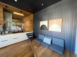悉尼The Ryokan - Zen的一间带蓝色沙发的客厅和一间厨房