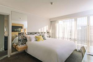 堪培拉堪培拉QT酒店的白色的卧室设有一张大床和一个窗户