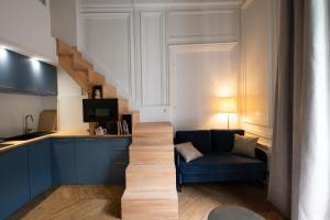 里昂Le Chavannes -Ecrin élégant & Cosy - Pentes de la Croix Rousse的一间带蓝色沙发的客厅和一间厨房
