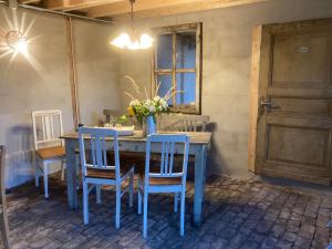 亚琛Gut Kalkhäuschen, ein Ort mit Geschichte的蓝色的餐桌,配有椅子和花瓶