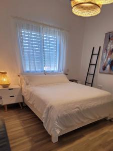 YuvalNaim Mountain View的卧室配有白色的床和窗户。