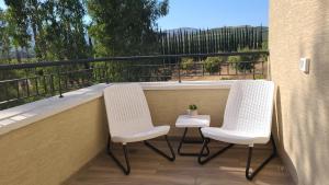 YuvalNaim Mountain View的阳台配有2把椅子和1张桌子