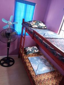 OtonBudget Home in Iloilo Staycation At 8 Pax的带风扇的客房内的两张双层床