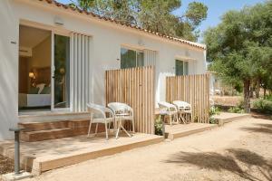 卡拉斯马略卡Iberostar Cala Domingos All Inclusive的房屋内带白色椅子的庭院