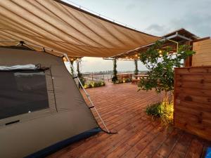 AtlitAtlit Rooftop Glamping的铺有木地板的甲板顶上的帐篷