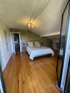 托朗格利耶尔Le chalet des Pesettes的一间卧室配有一张床,铺有木地板