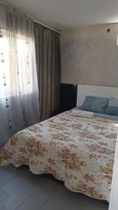乌雷基Cottage Teremok 7 people的一间卧室配有一张带花卉图案的毯子的大床
