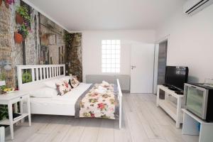 尼赖吉哈佐Villa Rose Garden的卧室配有白色的床和电视